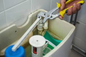 plumber repairing toilet tank